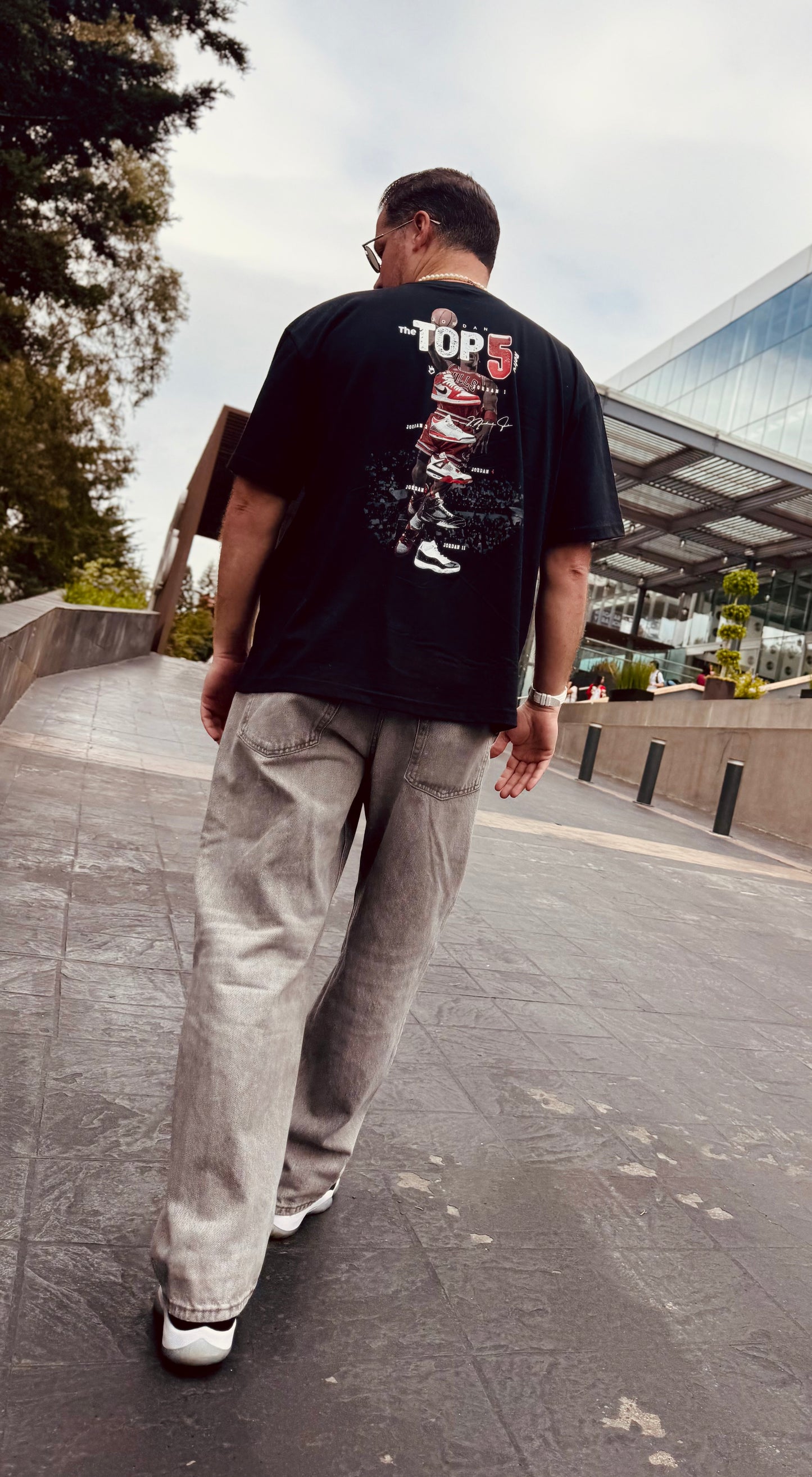 Modelando de espaldas la Playera de Jordan tipo Oversize gruesa de 220 g y 100% algodon.